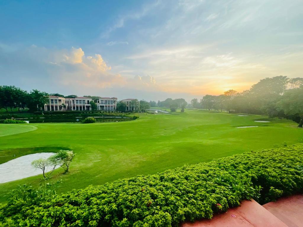 古尔冈Beautiful Apartments at Tarudhan Valley Golf Resort, Manesar的享有高尔夫球场和绿色美景