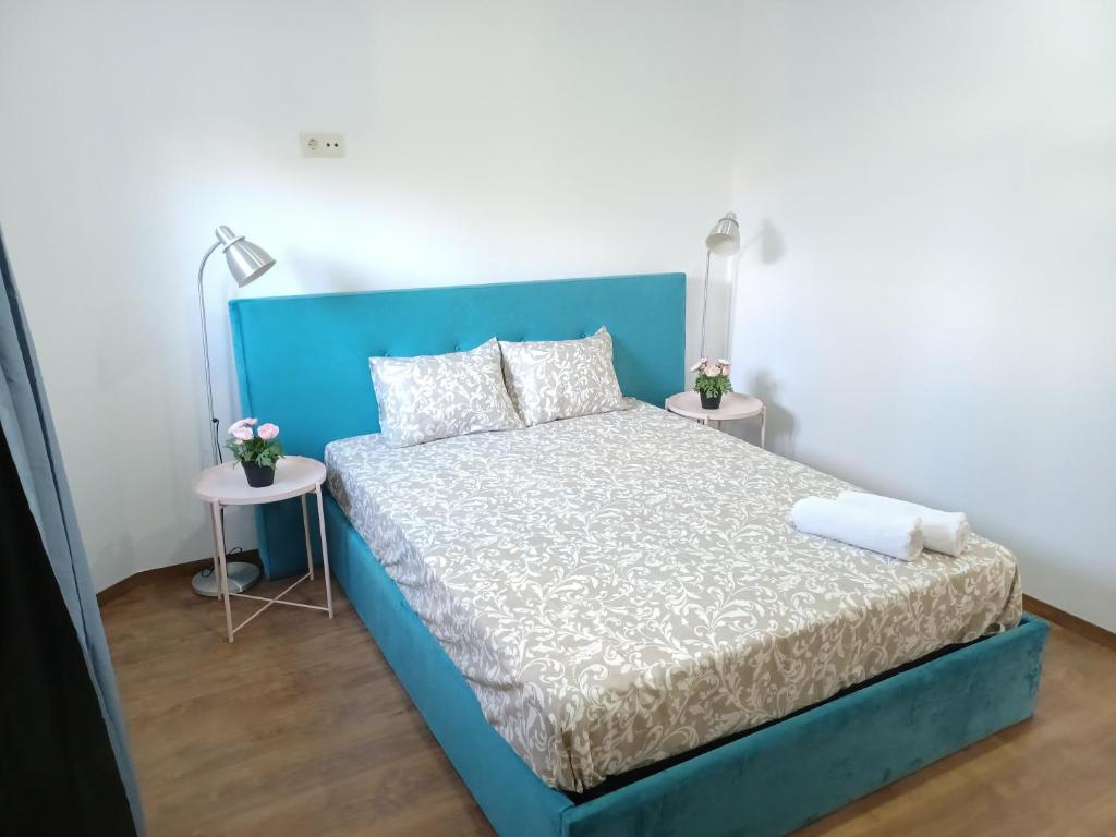 波尔图Enjoy Oporto Campanha 1的一张蓝色的床,房间设有两张桌子