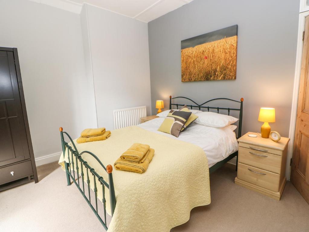 毕晓普奥克兰Church View Cottage的一间卧室配有床和一个带毛巾的梳妆台。