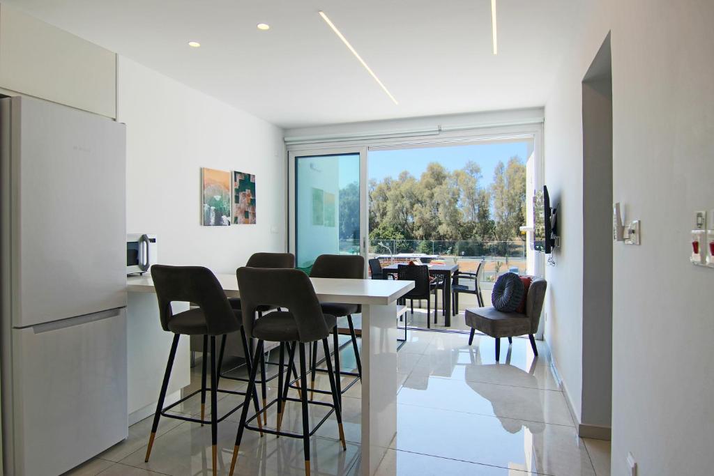 PaphosPhaedrus Living - Seaside Executive Flat Harbour 203的厨房以及带桌椅的用餐室。