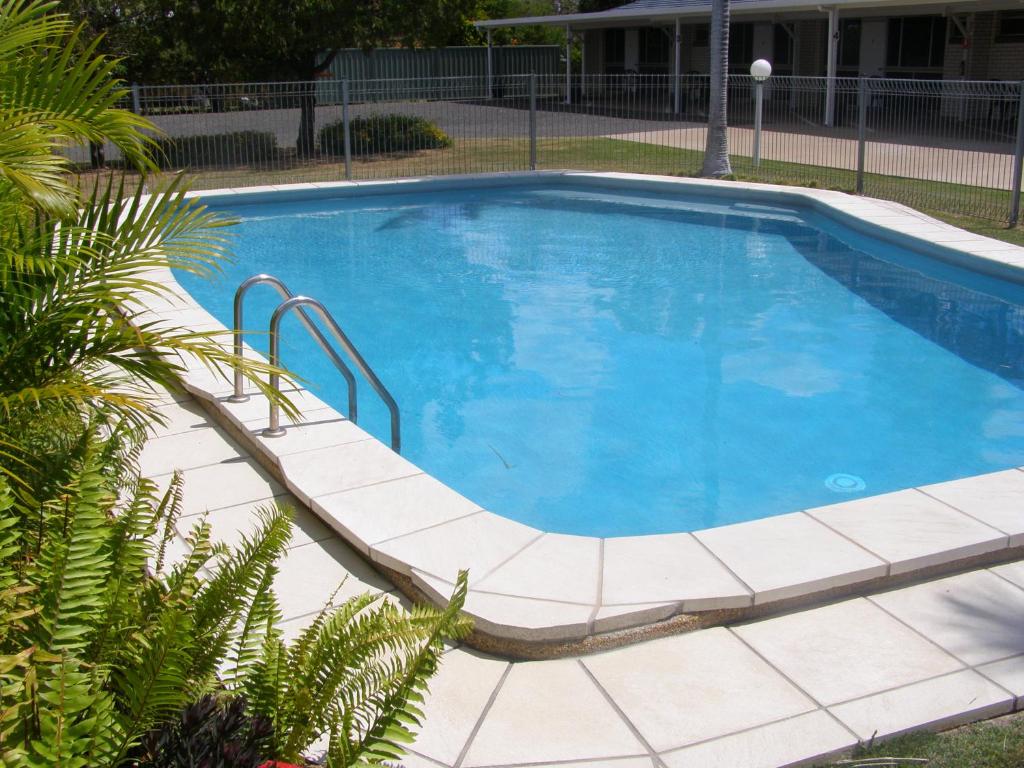 GayndahGayndah A Motel的一座大型游泳池,四周环绕着瓷砖庭院