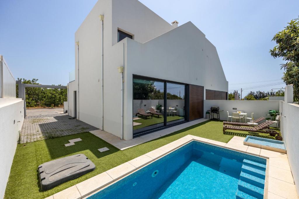 斯代塔维拉Villa Figo的一座带游泳池和庭院的现代房子