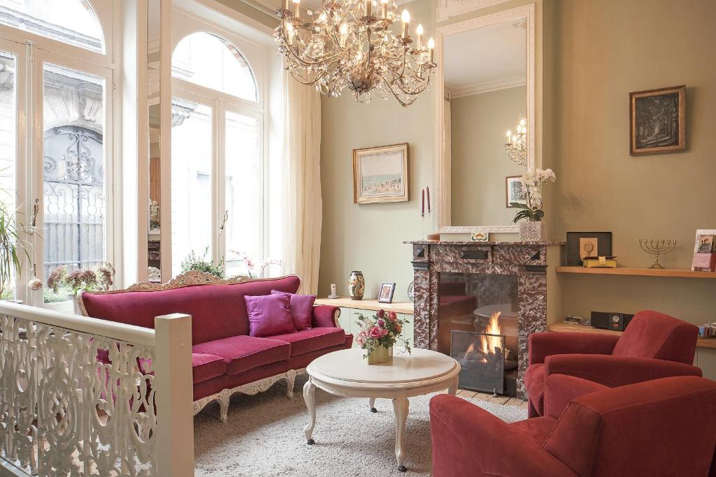 布鲁日布鲁日住宿加早餐旅馆的客厅配有紫色沙发和壁炉