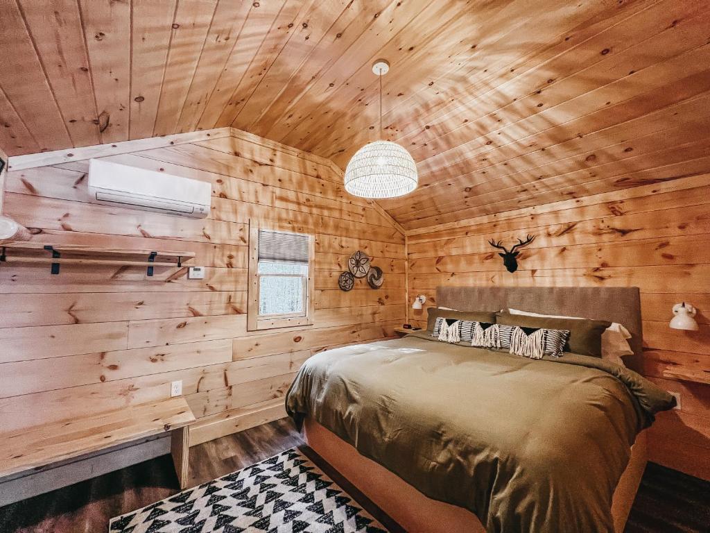 HartwellCabin #10 One Bedroom W Kitchenette的一间带木墙的卧室和一张位于客房内的床