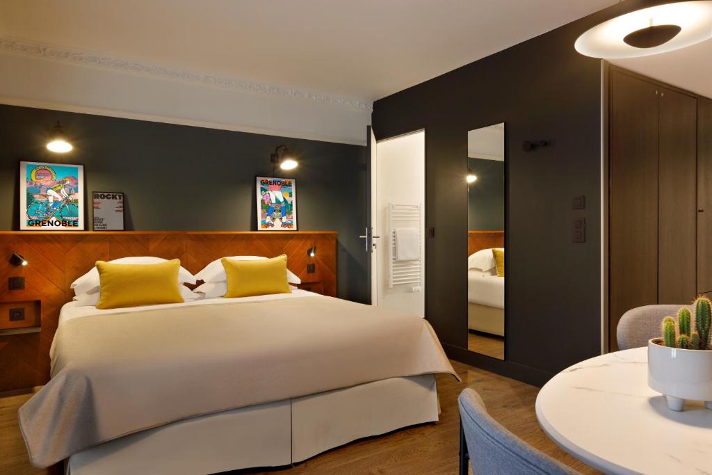 格勒诺布尔RockyPop Grenoble Hotel的一间卧室配有一张带黄色枕头的大床
