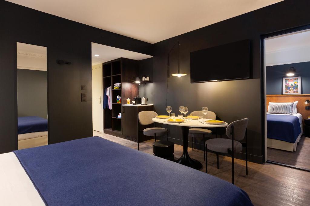 格勒诺布尔RockyPop Grenoble Appartements的酒店客房,配有一张床和一张桌子及椅子