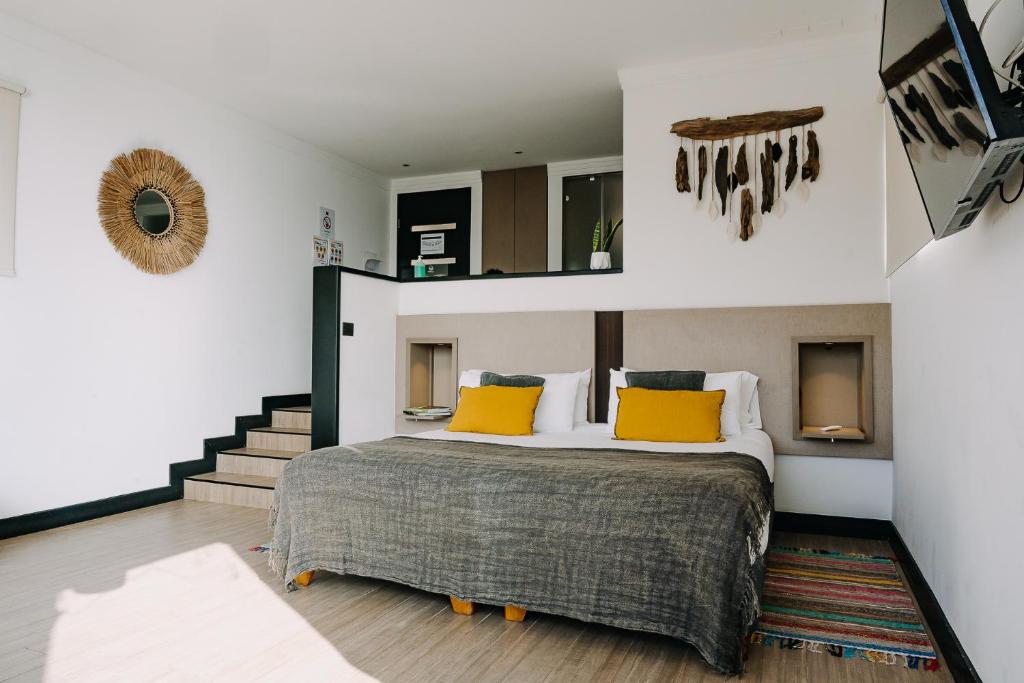 康塞普西翁Pura Lodge的一间卧室配有一张带黄色枕头的大床