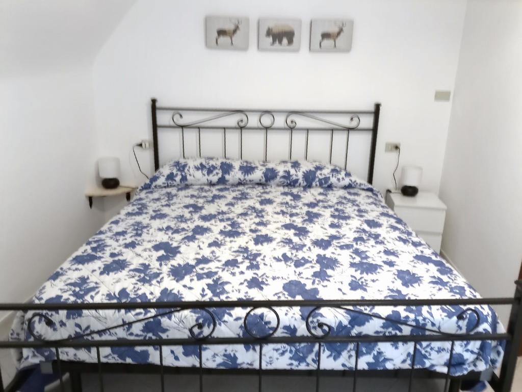 百瑞思西亚诺La Cameretta的一张带蓝色和白色棉被的床