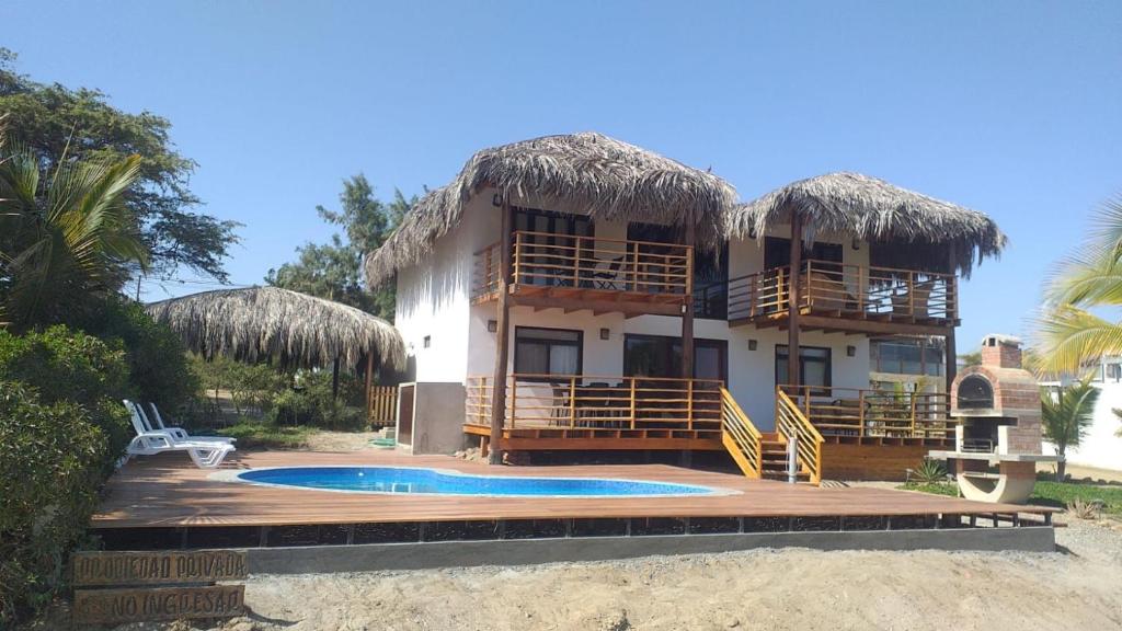 洛斯拉甘斯Casa Ananda Peru的一座带游泳池和度假村的别墅