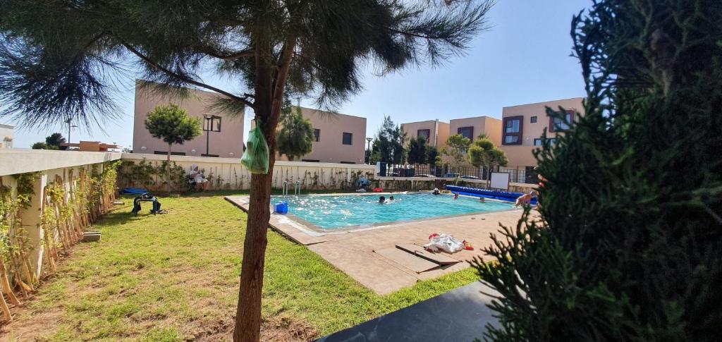 阿加迪尔Appartement luxe Taghazout bay - mer & piscine的院子里的游泳池,里面的人