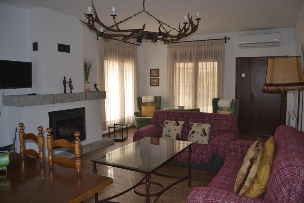 安度亚尔Alojamiento Rural Dehesa La Estancia的客厅设有红色的沙发和壁炉