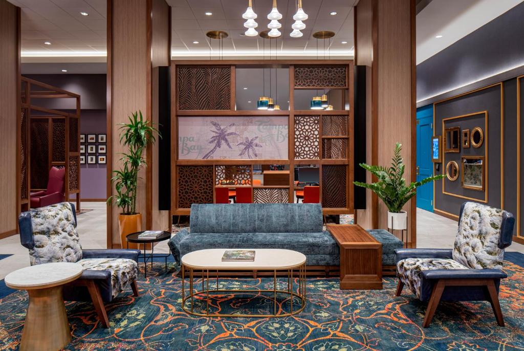 坦帕Hyatt House Tampa Downtown的大堂设有蓝色的沙发和两把椅子