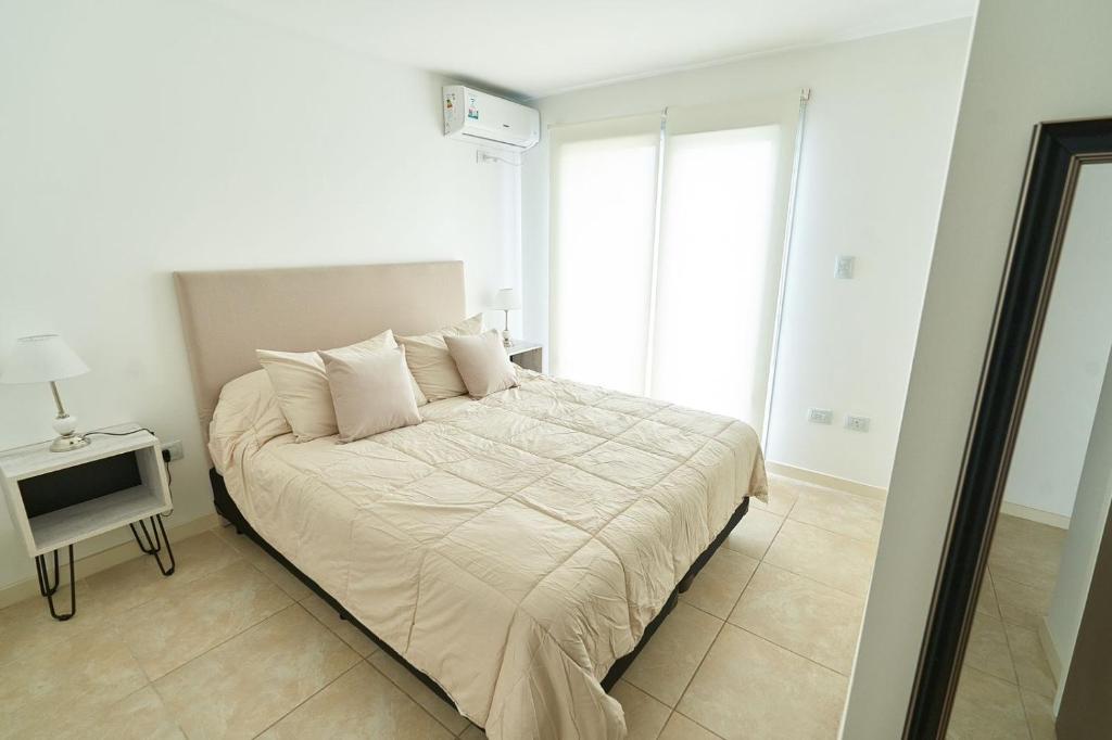 内乌肯VioletasNeuquen的卧室配有一张带白色床单和枕头的大床。
