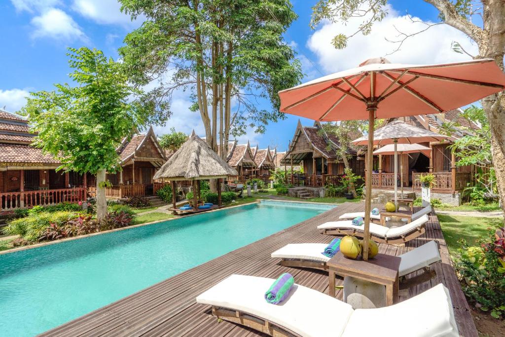 乌鲁瓦图My Dream Bali的一张带椅子和遮阳伞的度假村游泳池的图片
