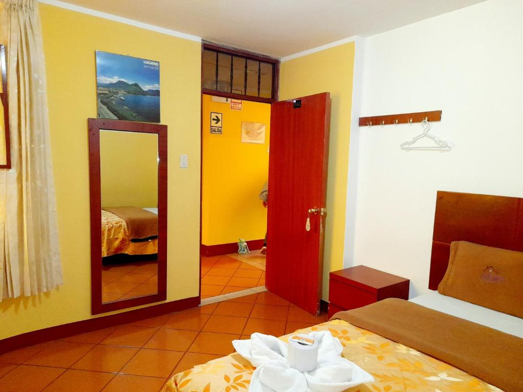 万卡约Hospedaje Las Lilas的带2张床和镜子的客房以及一间卧室