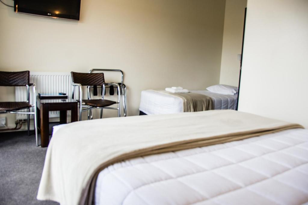 蒂阿瑙峡湾酒店的酒店客房,配有两张床、一张桌子和一把椅子