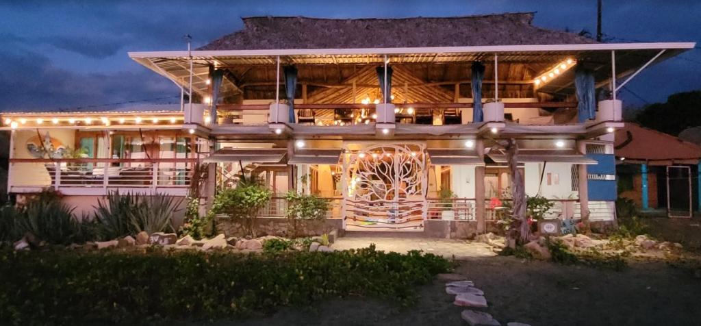 MiramarSirena Surf Lodge Miramar Nicaragua的夜晚有灯光的外墙的房子