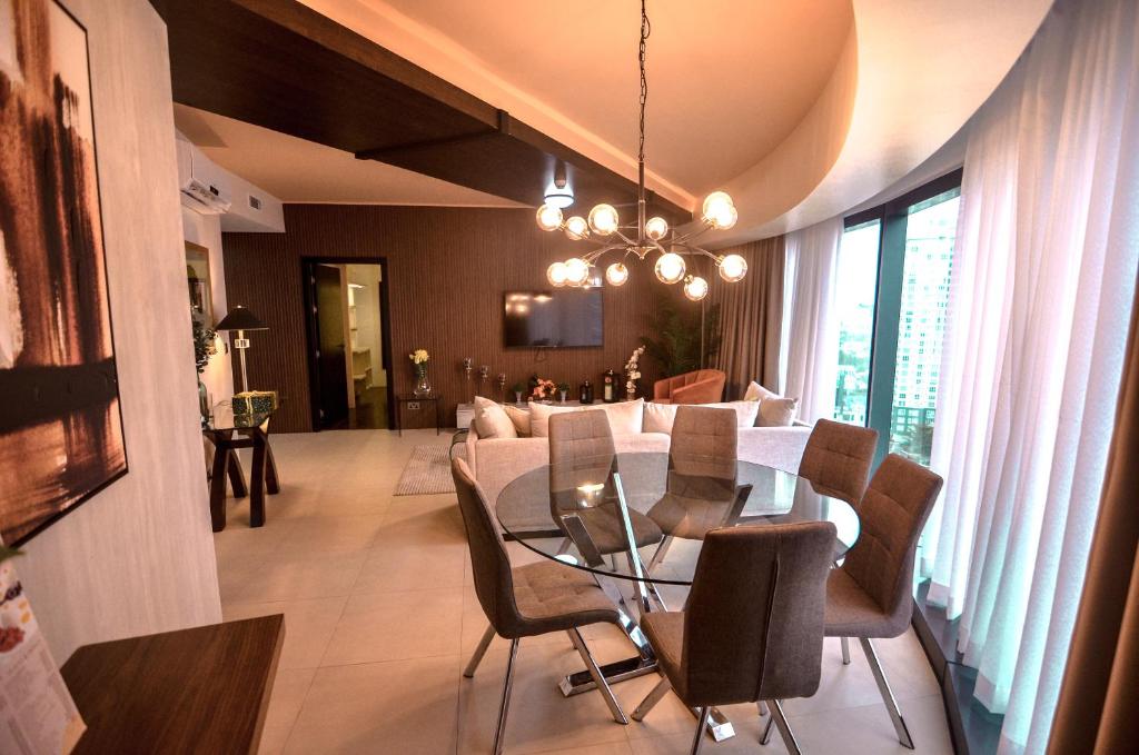 达沃市AEON SUITES STAYCATION managed by ARIA HOTEL的用餐室以及带桌椅的起居室。