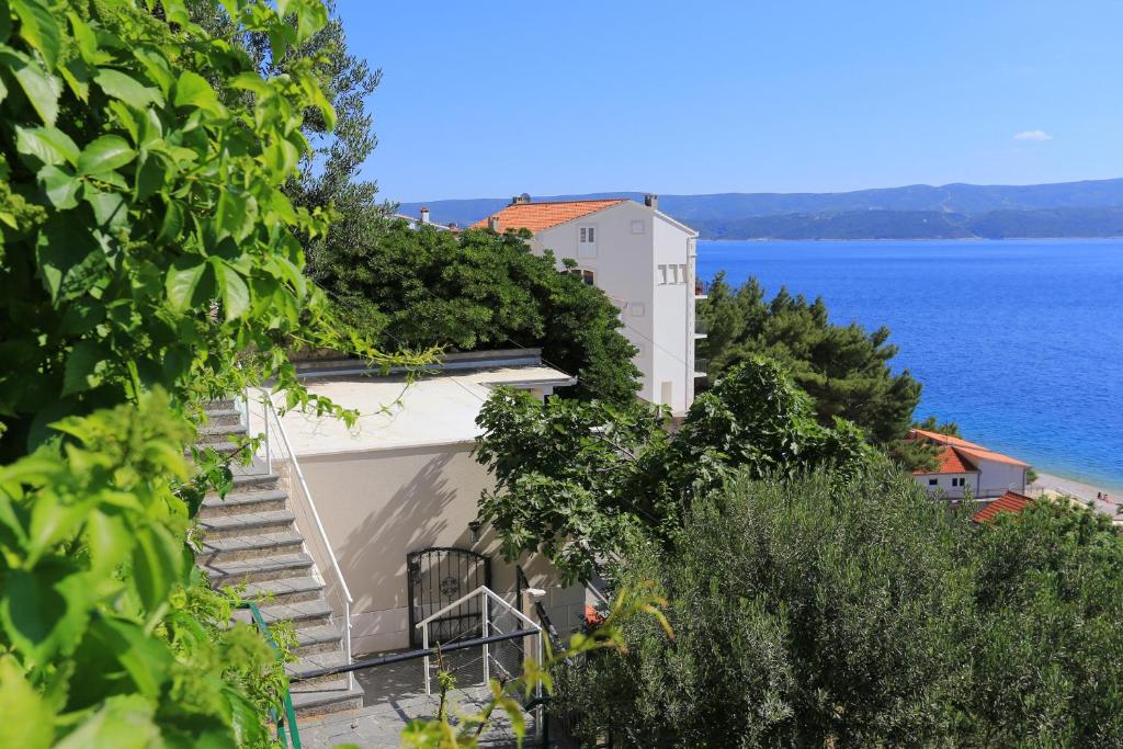 泰斯Seaside holiday house Stanici, Omis - 10357的海边的白色建筑,设有楼梯