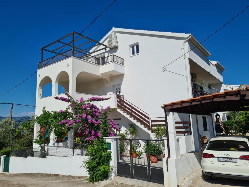 特罗吉尔Apartments by the sea Arbanija, Ciovo - 11321的前面有鲜花的白色房子