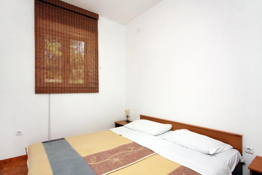 古维达里Apartment Pomena 10426b的卧室配有两张床,墙上挂着一幅画