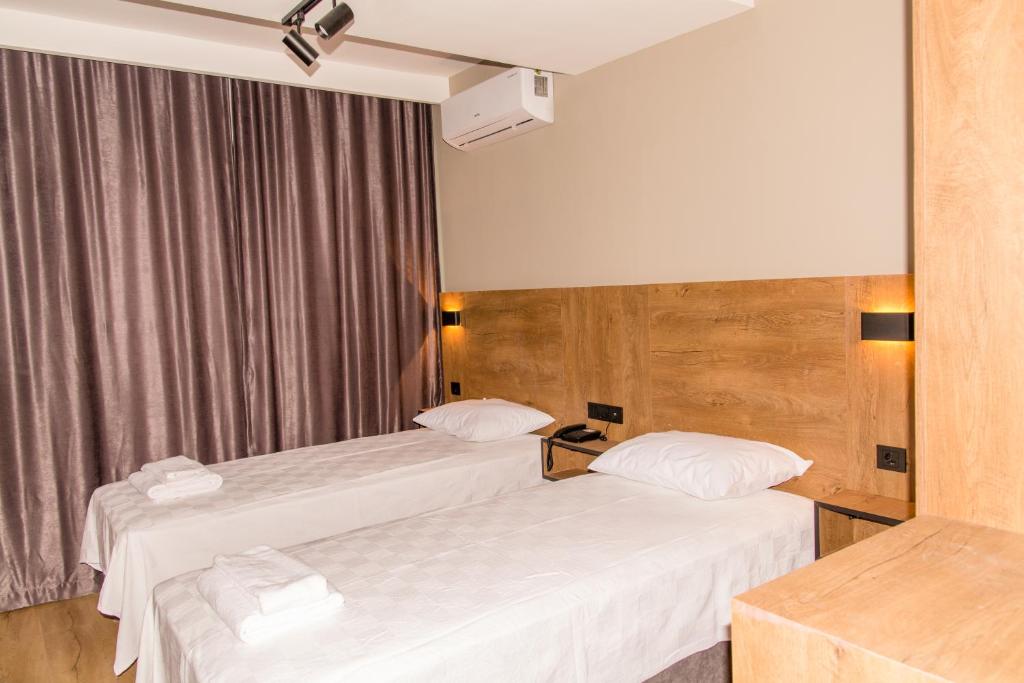 乔尔卢Fidanoğlu Suite Hotel Çorlu的配有白色床单的酒店客房内的两张床