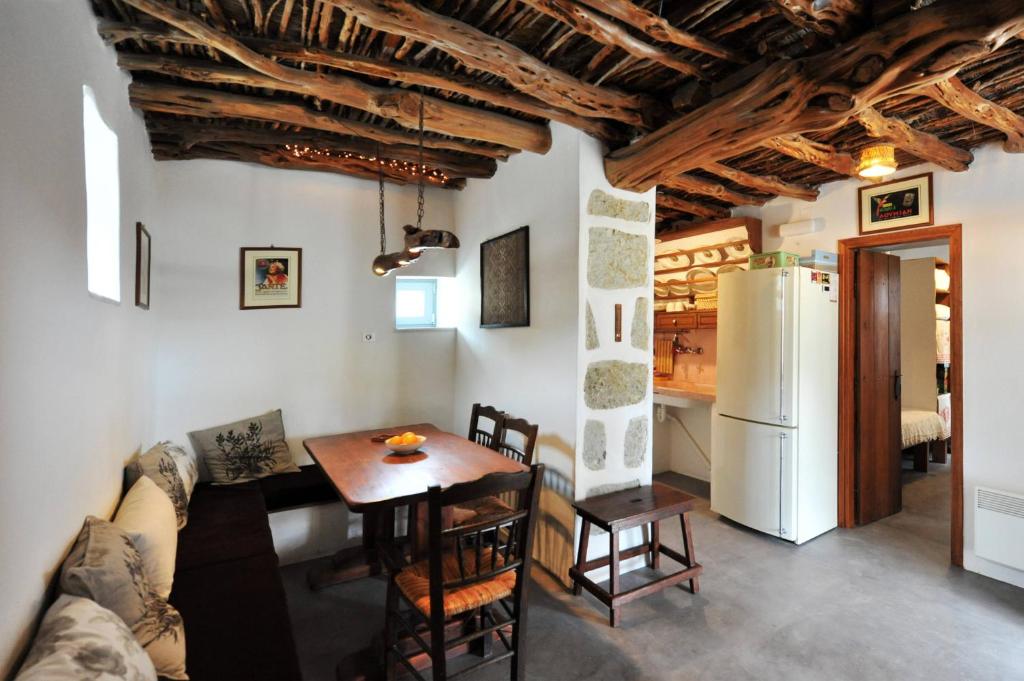 RalakiGiourgas Cottage Milos Island的厨房以及带桌子和冰箱的客厅。