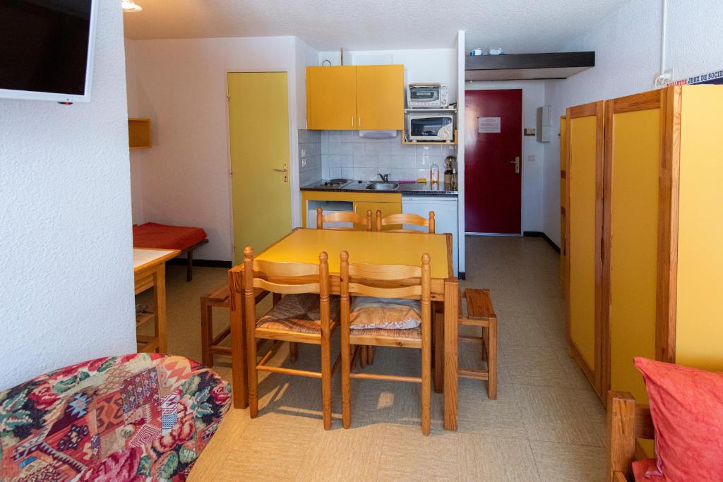 雷阿隆Appartement Chabrières的厨房以及带桌椅的用餐室。