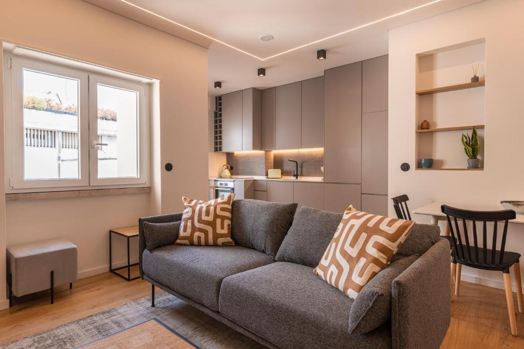 里斯本Charming Design Apartment的带沙发的客厅和厨房
