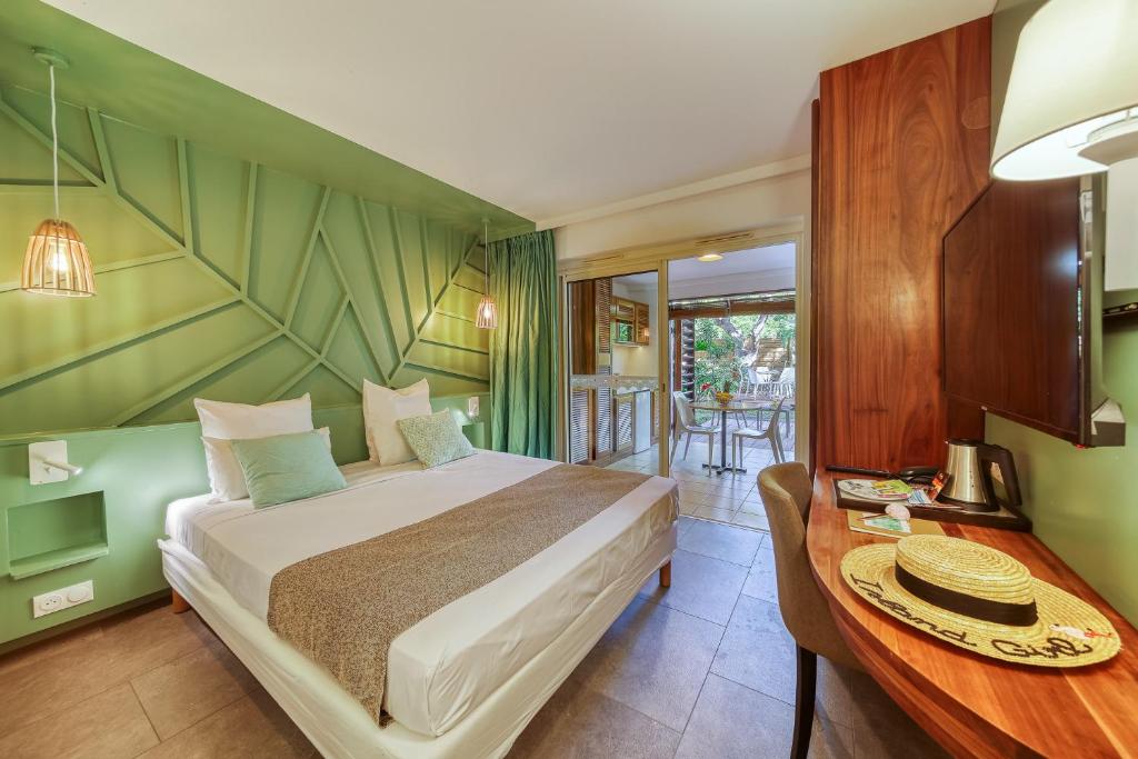 圣吉尔莱班热带公寓酒店的一间卧室配有一张床、一张桌子和一张桌子
