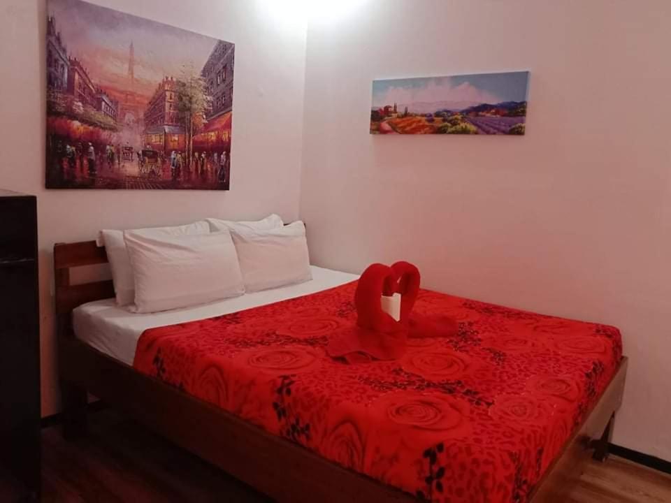 爱妮岛KIMURA PENSION的一间卧室配有一张带红毯和玫瑰的床