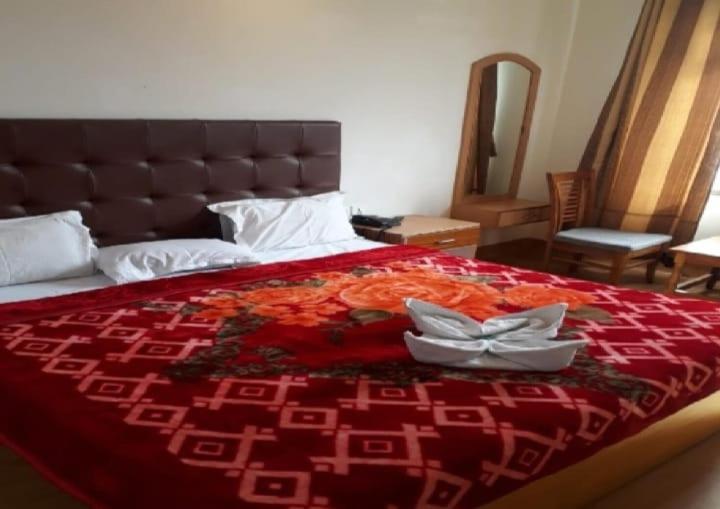 阿格拉Krishna Guest House By WB Inn的一张红色床罩的床,上面有两盘