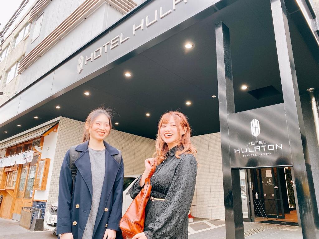 福冈福冈博多弗拉顿酒店的两个女人站在商店前