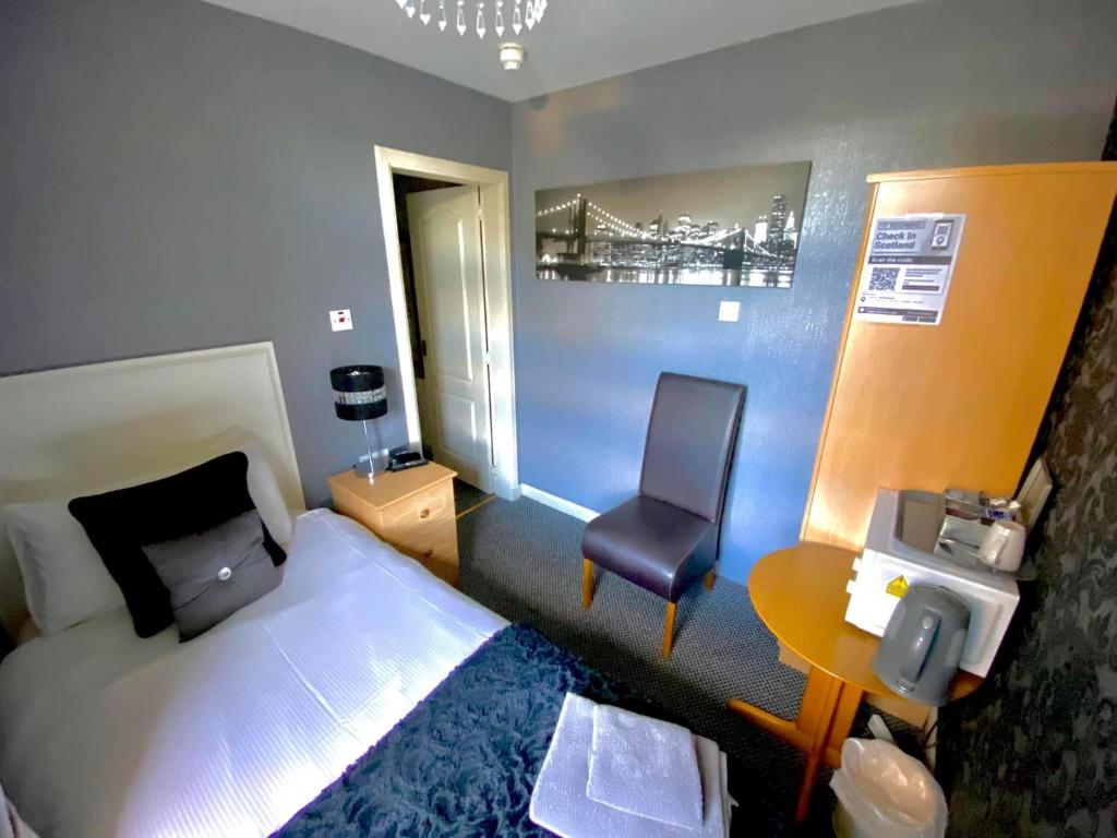 阿伯丁瓦拉旅馆的一间卧室配有一张床、一张桌子和一把椅子