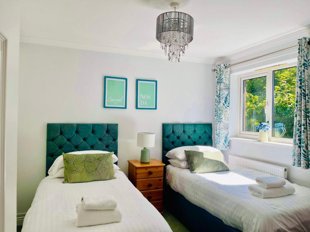 阿伯加文尼Tanglewood house Abergavenny with private parking的一间卧室配有两张床和吊灯。