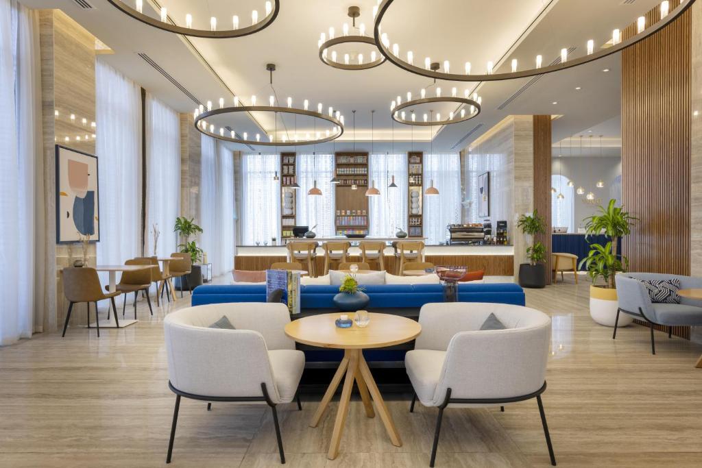 多哈voco Doha West Bay Suites, an IHG Hotel的大堂设有蓝色的沙发和椅子