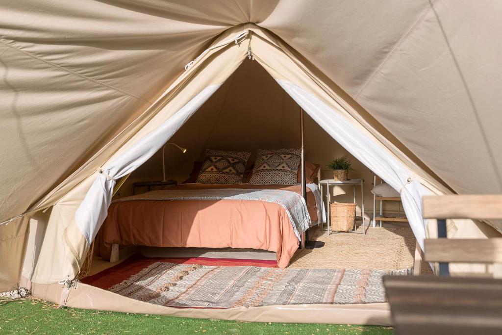 科尼尔-德拉弗龙特拉Glamping La Mimosa CONIL的帐篷内一间卧室,配有一张床