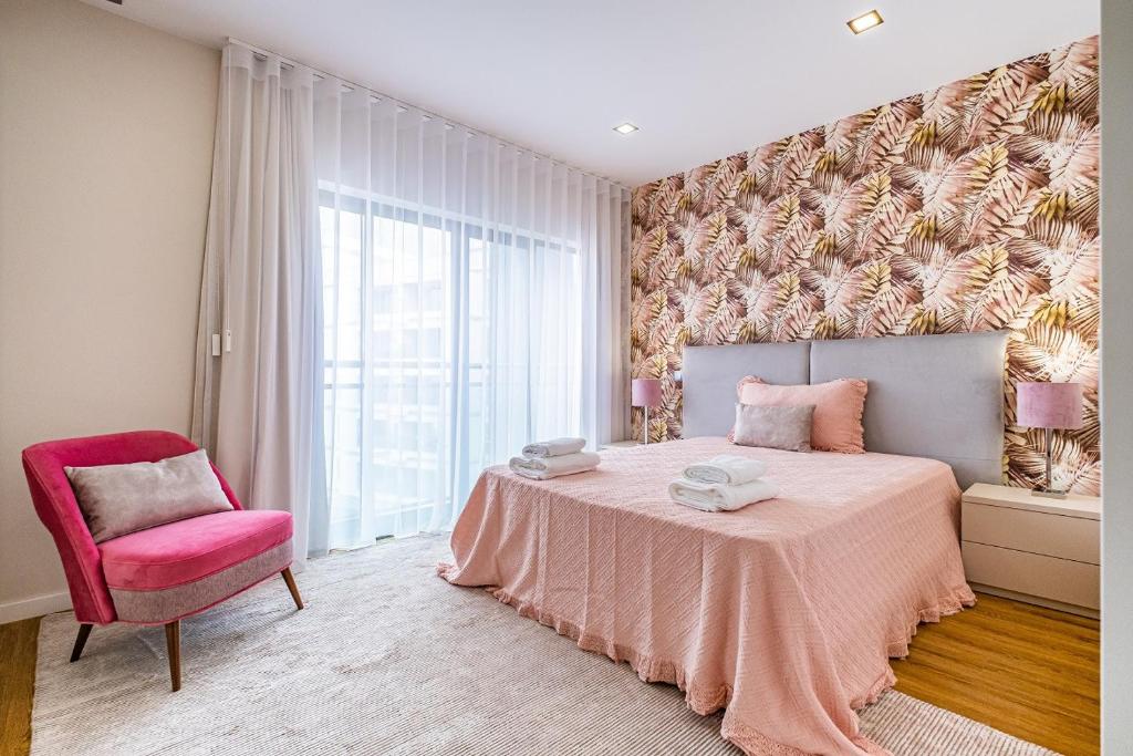 丰沙尔Urban Paradise by Madeira Sun Travel的卧室配有粉红色的床和粉红色的椅子