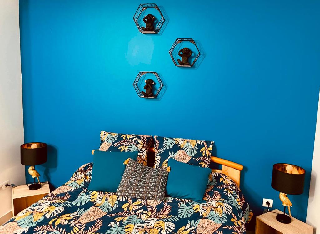 PoncinsLa Villa Perroquet的蓝色的卧室,配有一张蓝色墙壁的床
