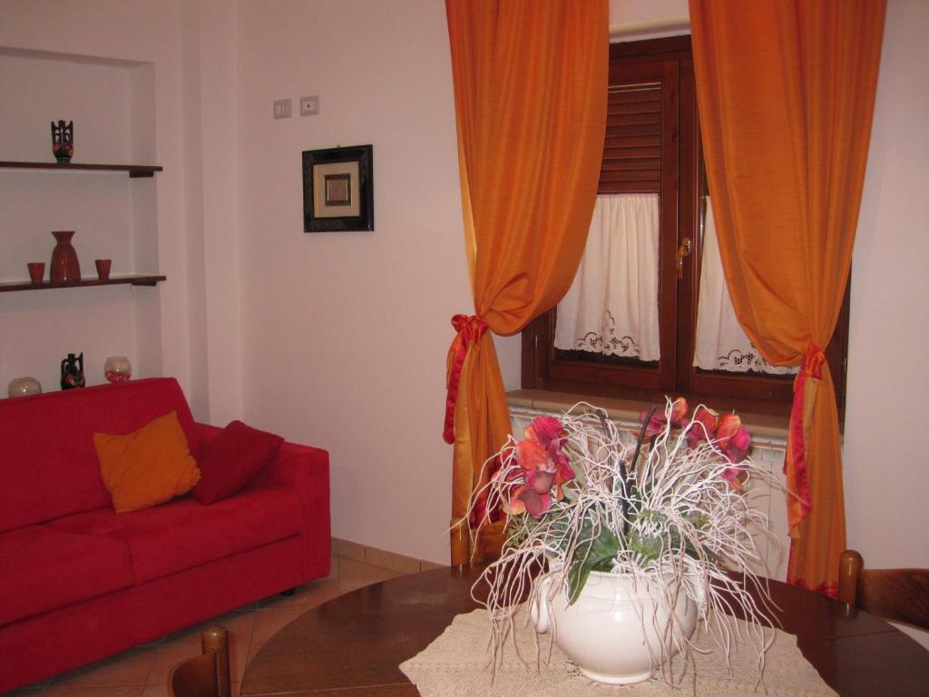 StronconeLa Casetta Arancione appartamento的客厅配有红色的沙发和桌子