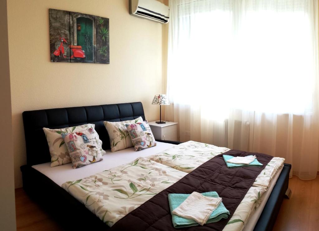 布达佩斯花园旅馆的卧室内的一张大床,设有窗户