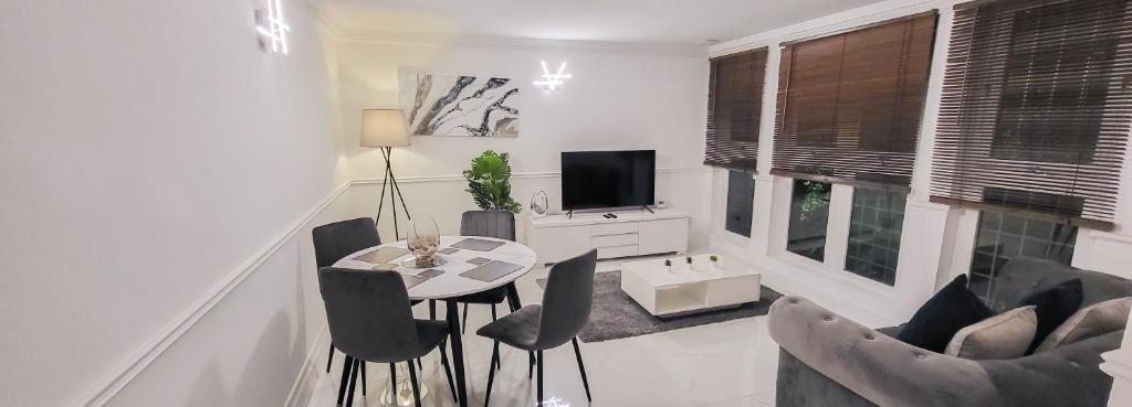 伦敦Stunning 2 bedroom apartment in Canary Wharf - Morland Apartments的客厅配有桌椅和电视。