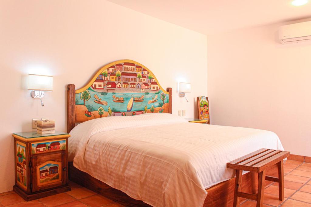 瓦哈卡市Casa Rosa Mexicano的一间卧室配有一张大床和木制床头板