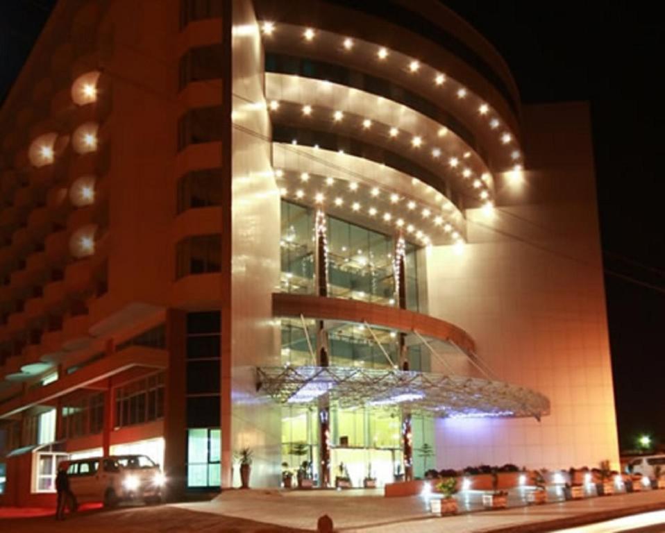亚的斯亚贝巴Inter Luxury Hotel的一座建筑,在晚上前有吊灯