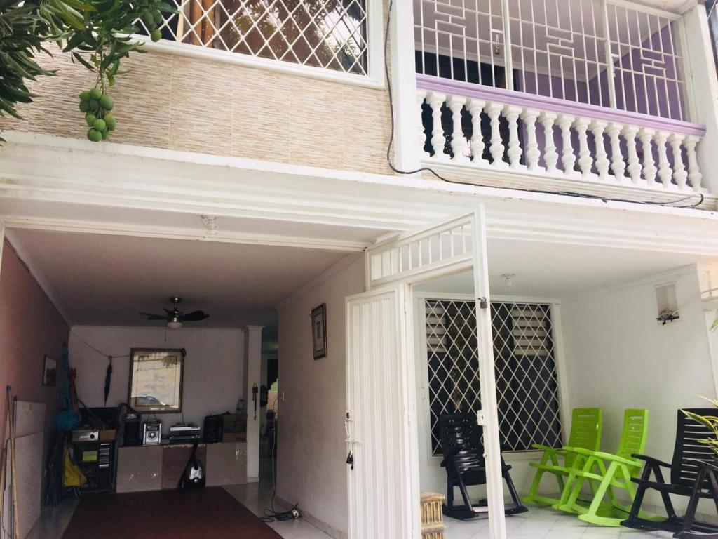 圣玛尔塔Casa Feliz Hostal的阳台,带绿色椅子