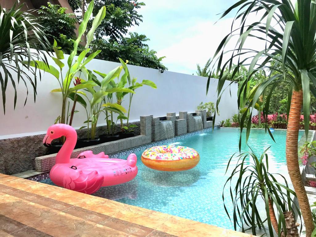 Gadok 1THE OASIS 4BR Private Pool Pet-Friendly Villa Vimala Hills的水中带两个粉红色火烈鸟的游泳池