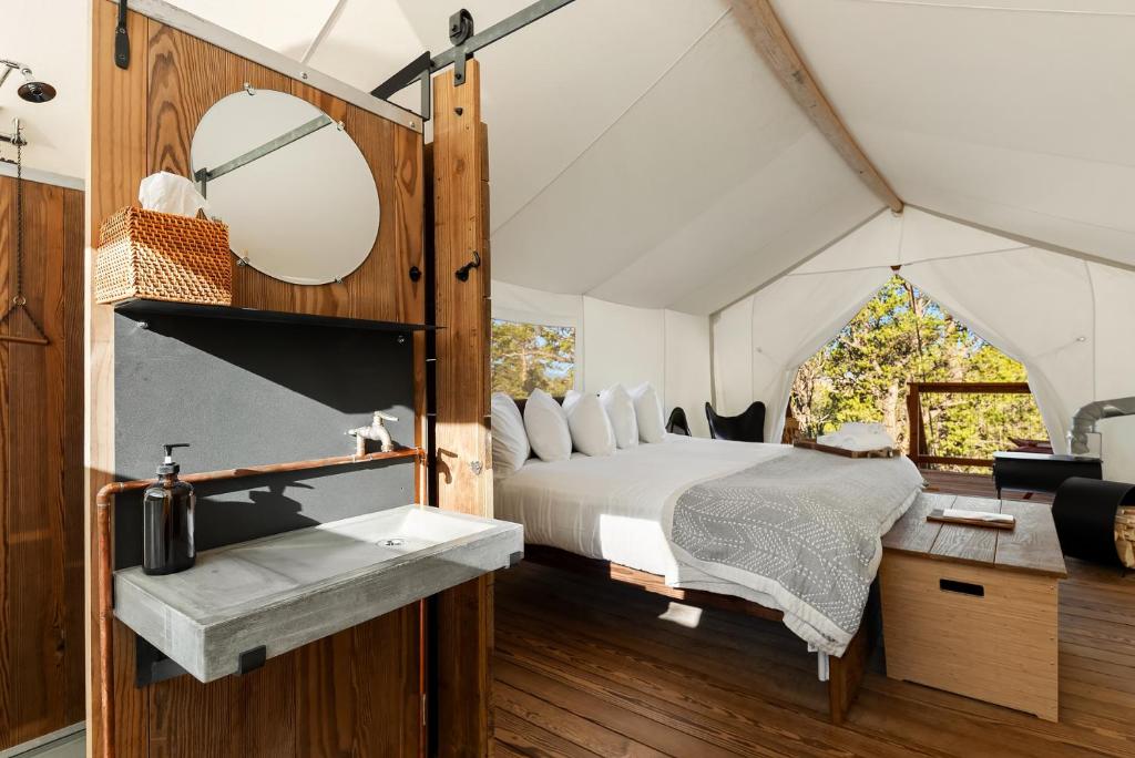 WidtsoeUnder Canvas Bryce Canyon的帐篷内的卧室配有床和水槽