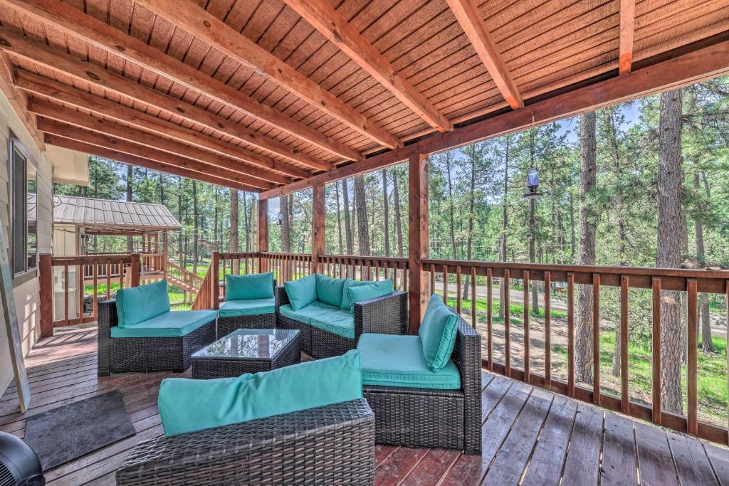 鲁伊多索Pet-Friendly Ruidoso Home with Deck and Forest Views!的一个带桌椅的屏蔽门廊