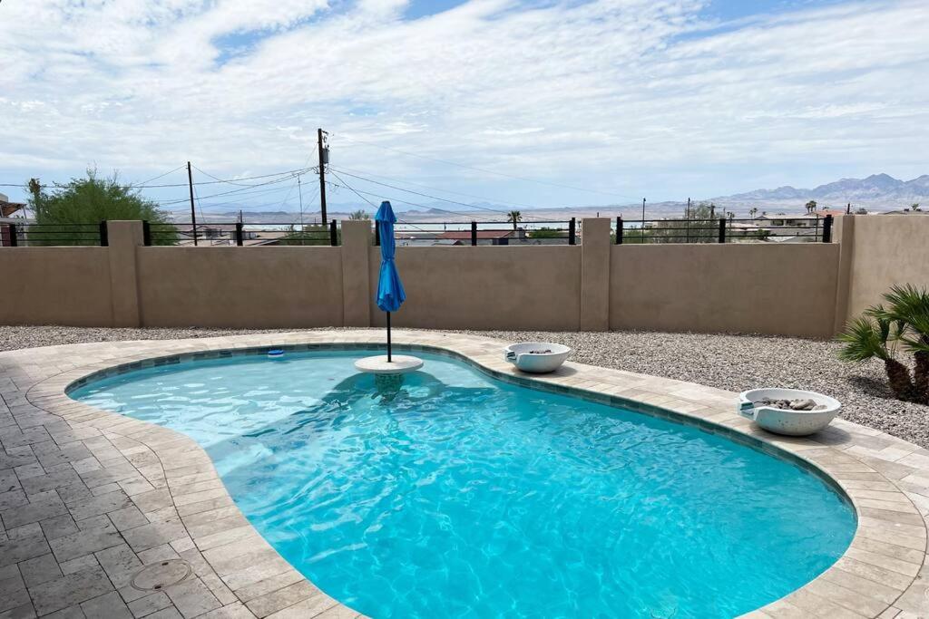 哈瓦苏湖城Havasu Retreat! Pool, Spa, Gym & View的庭院内一个带遮阳伞的游泳池