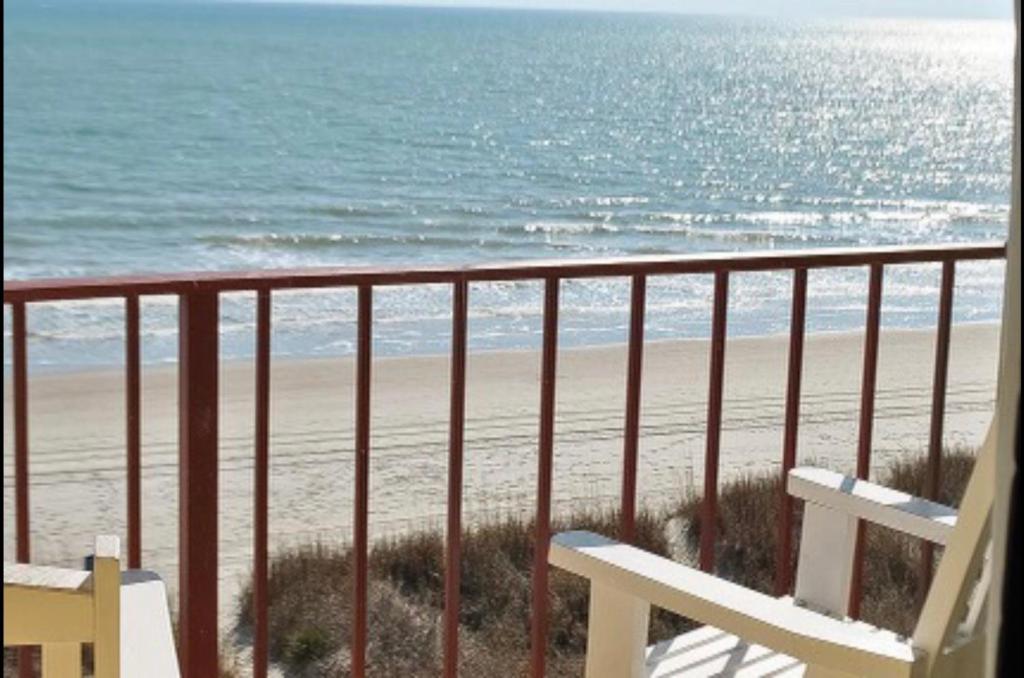 默特尔比奇Gazebo Inn Oceanfront的享有海滩和长凳景致的阳台